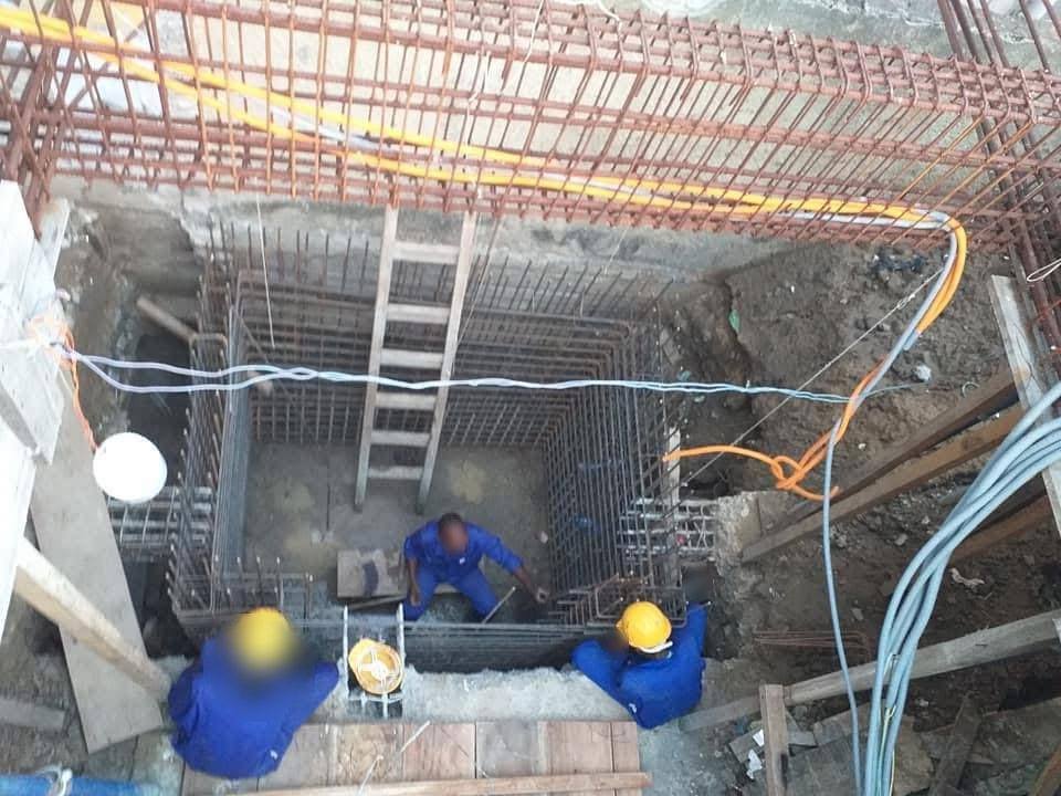 Ouvriers dans une fouille avec des cages d'armatures, vue de dessus