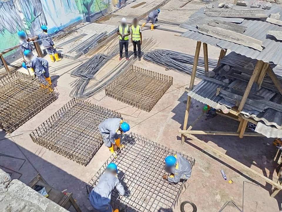 Ouvriers assemblant des cages d'armatures, vue de dessus